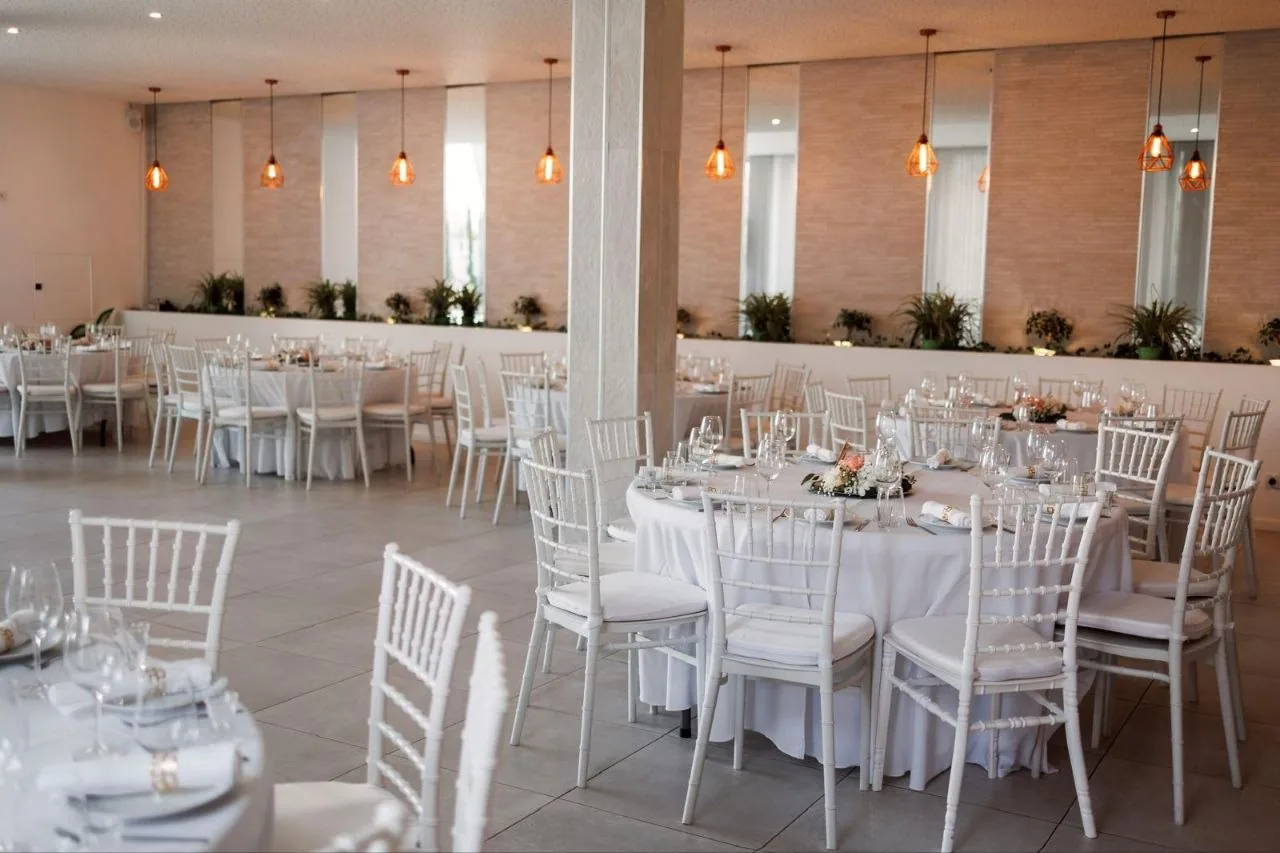 Sala montada com mesas redondas para um evento
