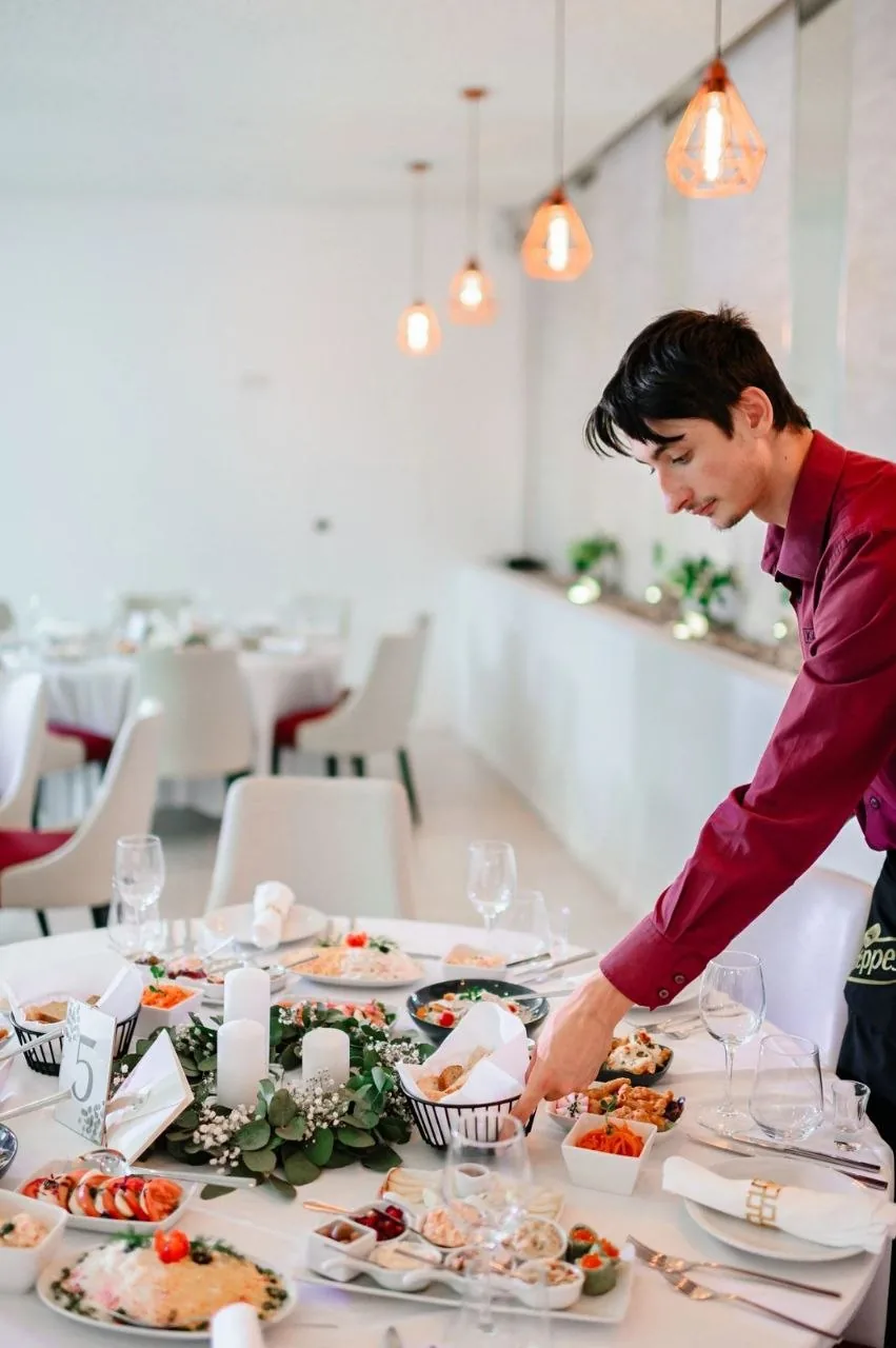 Empregado a servir numa mesa posta para um evento