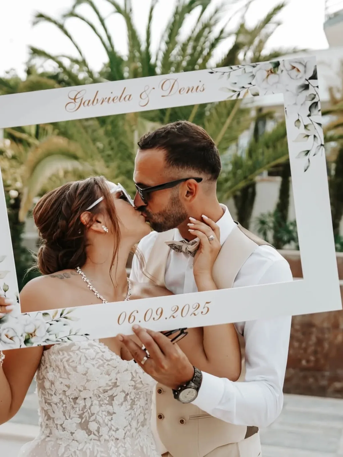 Noivos numa moldura de fotos decorada com a data do casamento